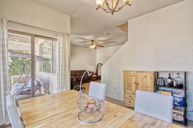 dining room with ceiling fan with notable chandelier and light hardwood / wood-style flooring