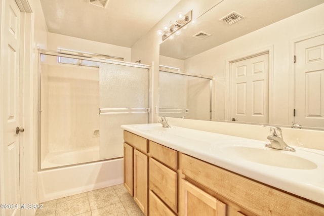 bathroom featuring vanity, combined bath / shower with glass door, and tile patterned floors