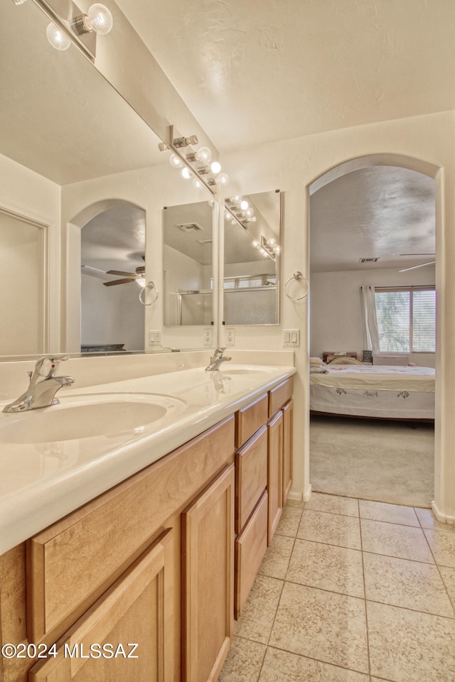 bathroom with tile patterned flooring, vanity, and ceiling fan