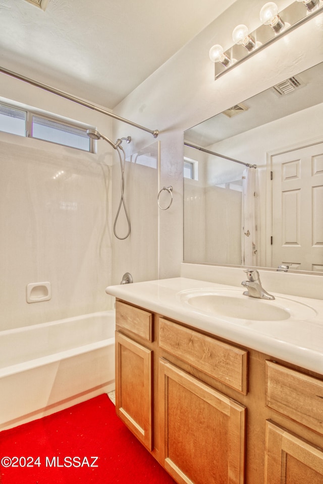 bathroom featuring plenty of natural light, vanity, and bathtub / shower combination