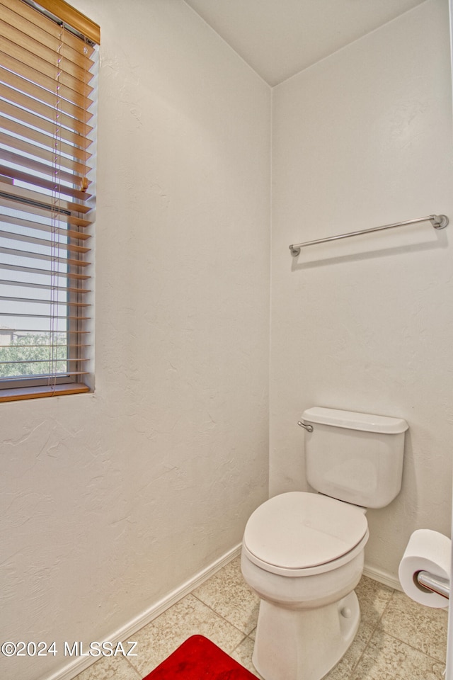 bathroom with toilet and tile patterned flooring