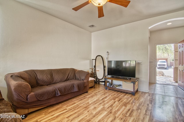 living room featuring light hardwood / wood-style floors, ceiling fan, and vaulted ceiling