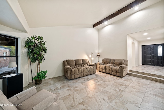 living area with marble finish floor and lofted ceiling with beams