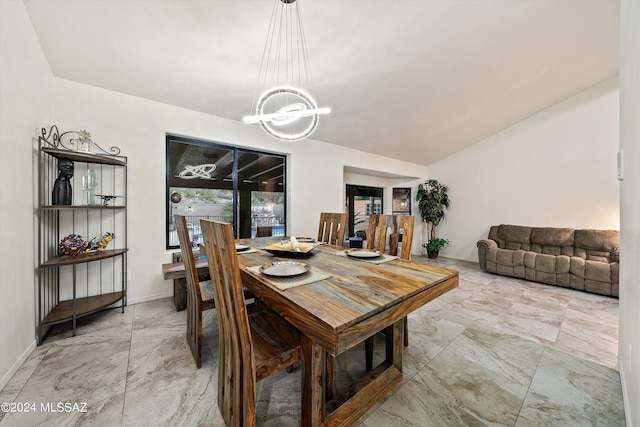 dining area with an inviting chandelier and vaulted ceiling