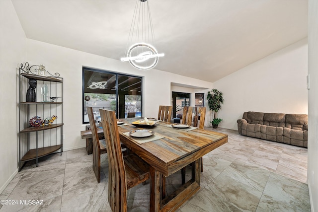 dining area with a chandelier, marble finish floor, baseboards, and vaulted ceiling