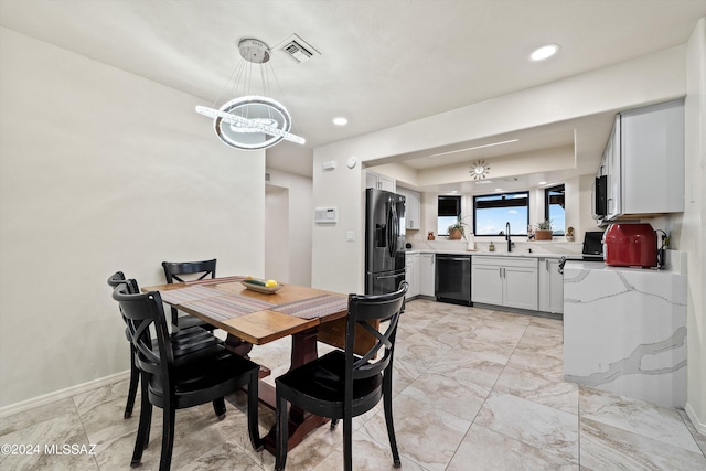 dining space with sink and a notable chandelier