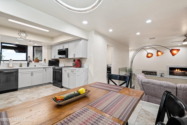 kitchen featuring ceiling fan, stainless steel appliances, white cabinetry, and sink