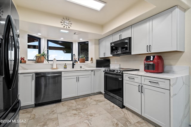 kitchen with visible vents, light stone countertops, appliances with stainless steel finishes, marble finish floor, and a sink