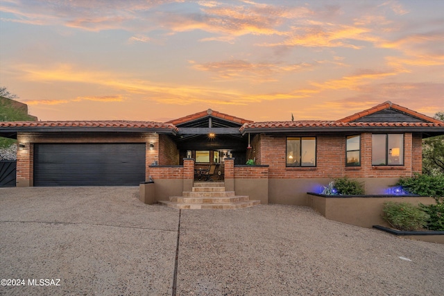 view of front of property with concrete driveway, an attached garage, and a tiled roof