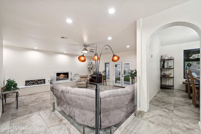 living room featuring ceiling fan and french doors