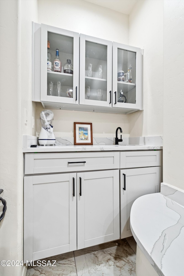 bar with a sink and marble finish floor