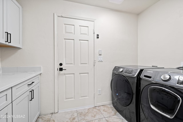 clothes washing area featuring separate washer and dryer, cabinets, and light tile patterned floors