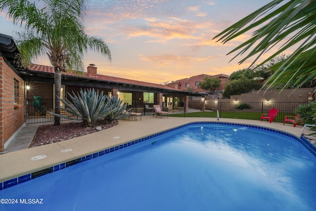 pool at dusk with a patio