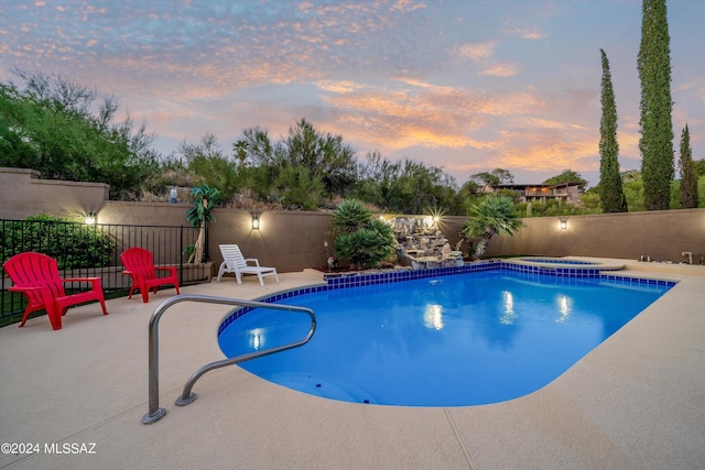 pool at dusk featuring a patio area, a fenced in pool, and fence