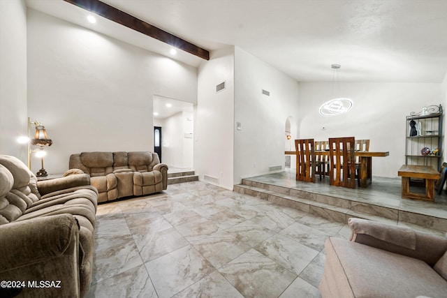 living room featuring beamed ceiling, arched walkways, marble finish floor, and a chandelier