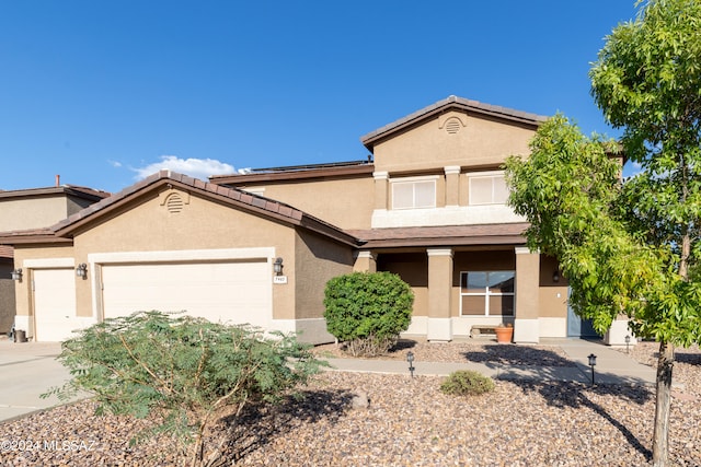 view of front of house with concrete driveway, a tiled roof, an attached garage, and stucco siding