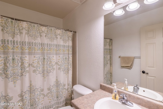 bathroom featuring vanity, toilet, and a shower with curtain