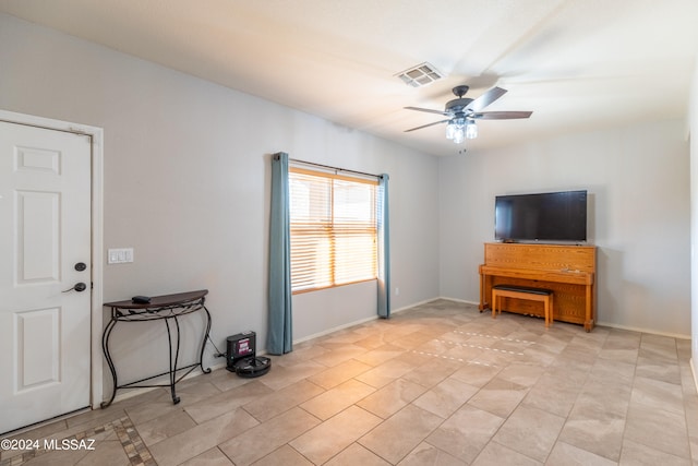 living area featuring ceiling fan, visible vents, and baseboards