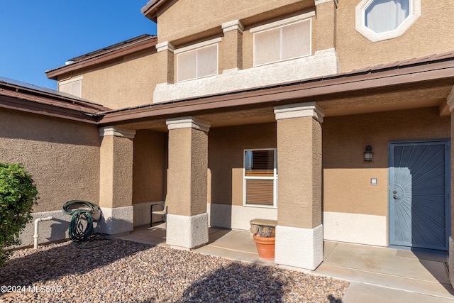 view of exterior entry featuring a patio