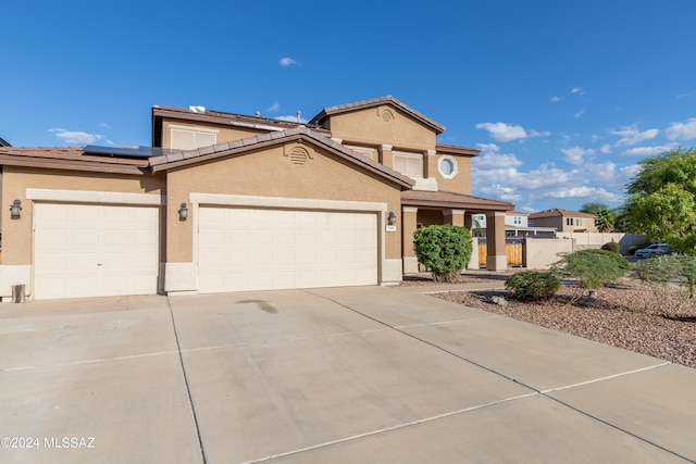 view of front of home featuring a garage and solar panels