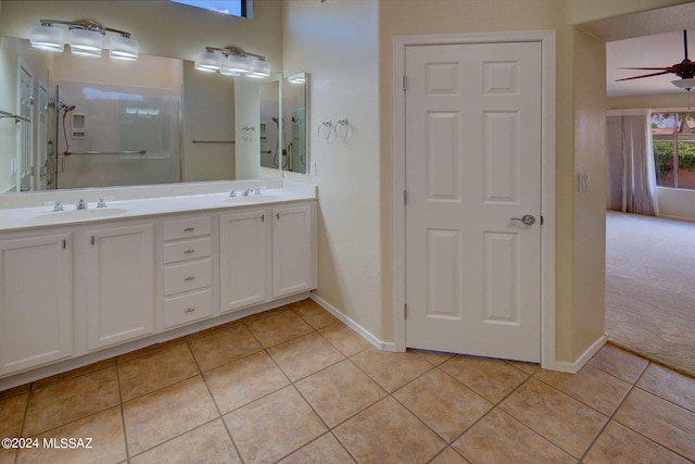 bathroom with ceiling fan, vanity, a shower with shower door, and tile patterned flooring