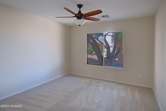 empty room featuring ceiling fan and light colored carpet