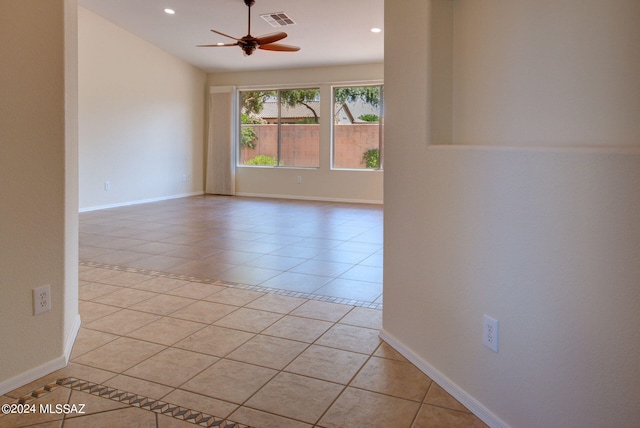 tiled spare room with ceiling fan