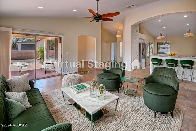 living room featuring lofted ceiling, ceiling fan, and light tile patterned floors