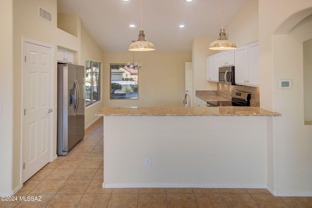 kitchen with kitchen peninsula, lofted ceiling, pendant lighting, and stainless steel appliances