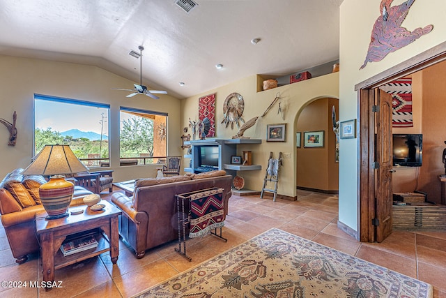 living room featuring lofted ceiling, light tile patterned floors, ceiling fan, and a textured ceiling