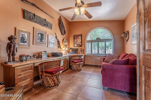 office with tile patterned flooring, built in desk, ceiling fan, and vaulted ceiling