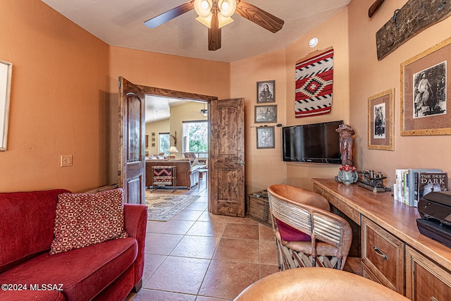 tiled living room featuring ceiling fan and vaulted ceiling