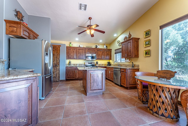 kitchen with a center island, ceiling fan, plenty of natural light, and stainless steel appliances