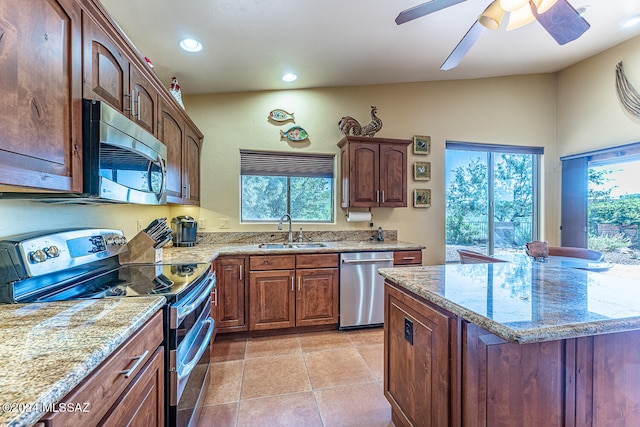 kitchen featuring appliances with stainless steel finishes, a healthy amount of sunlight, sink, and ceiling fan