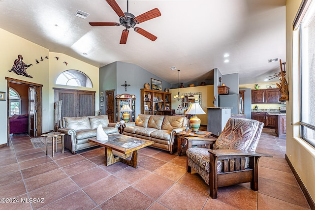 tiled living room featuring vaulted ceiling, a healthy amount of sunlight, and ceiling fan