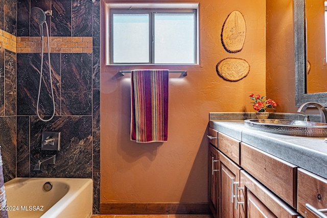 bathroom with tiled shower / bath combo and vanity