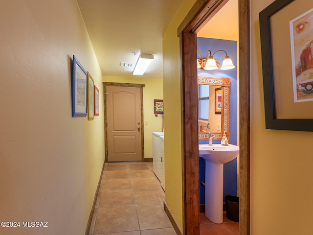 hallway featuring sink and light tile patterned floors