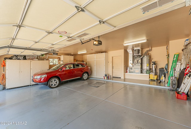 garage featuring a garage door opener, heating unit, and water heater