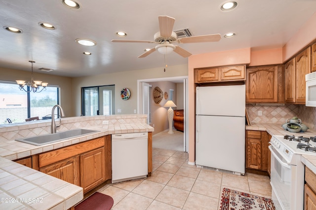 kitchen with light tile patterned floors, sink, kitchen peninsula, and tasteful backsplash