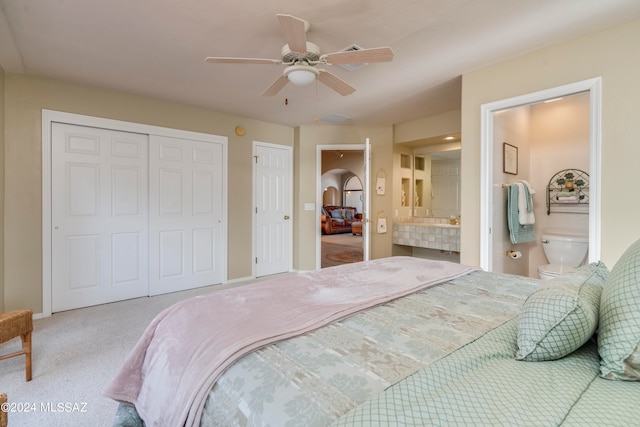 bedroom featuring ceiling fan, ensuite bath, and light carpet