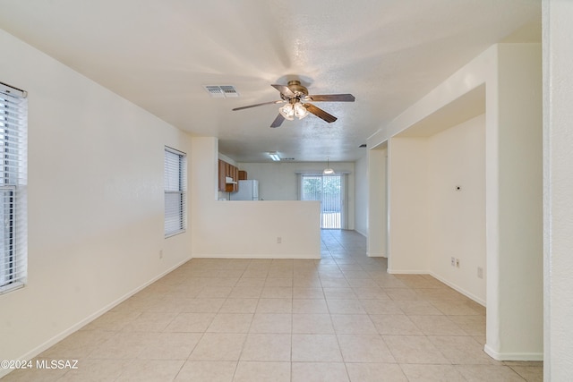 tiled empty room featuring a textured ceiling and ceiling fan