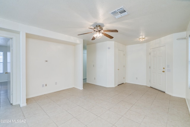 unfurnished room featuring ceiling fan and a textured ceiling