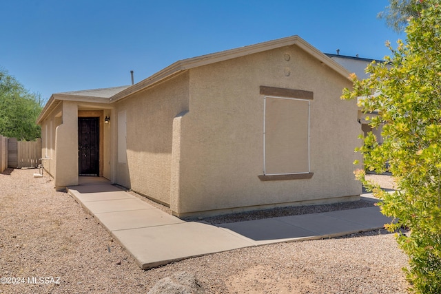 view of front of home featuring stucco siding and fence