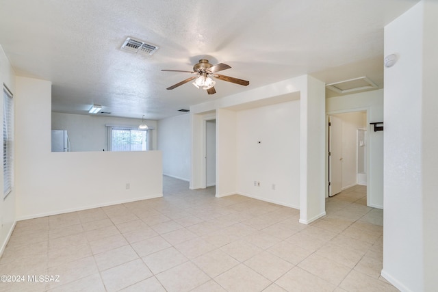 empty room with ceiling fan and a textured ceiling