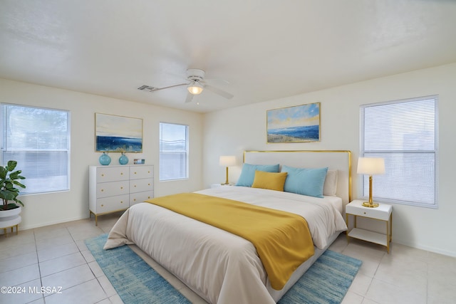 tiled bedroom with multiple windows and ceiling fan