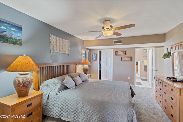 carpeted bedroom with ceiling fan and ensuite bath