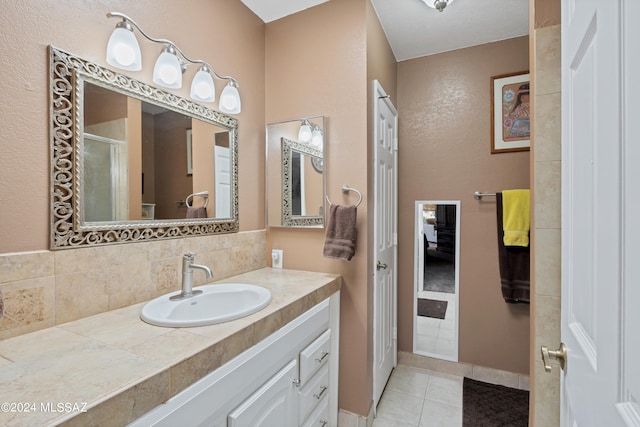 bathroom with vanity, an enclosed shower, tile patterned floors, and decorative backsplash