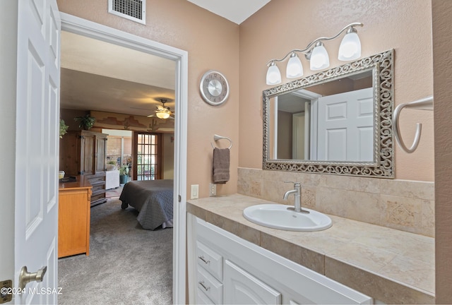 ensuite bathroom with visible vents, vanity, connected bathroom, decorative backsplash, and ceiling fan
