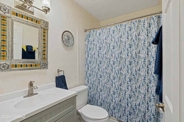 full bathroom with a shower with shower curtain, a textured wall, toilet, and vanity