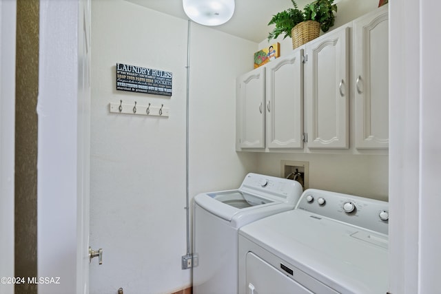 laundry area featuring washing machine and clothes dryer and cabinets